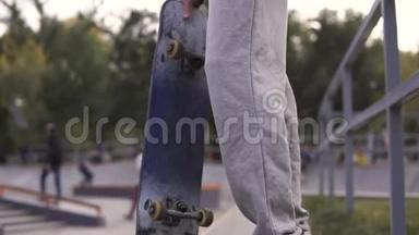 在秋天的城市里，年轻的街头风格的男人在溜冰场的边界上玩滑板